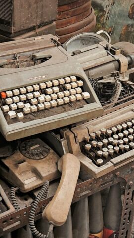 an old typewriter sitting on top of a pile of junk