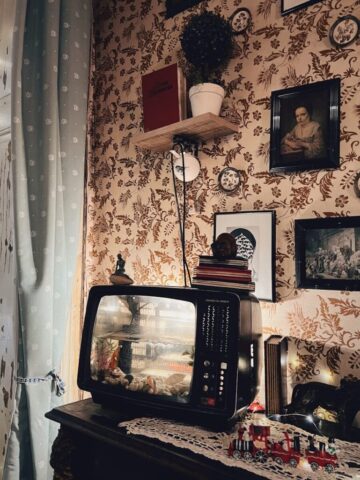 a tv sitting on top of a dresser next to a window