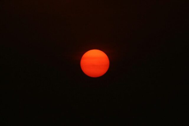 the sun is setting in the dark sky