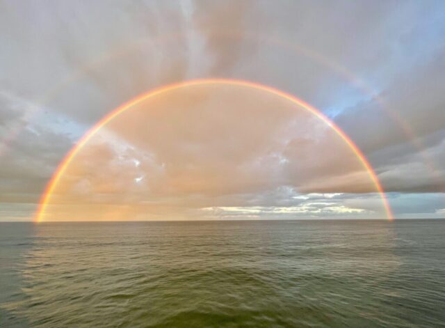 Photo by Cocodillaa.com a rainbow appears over a body of water