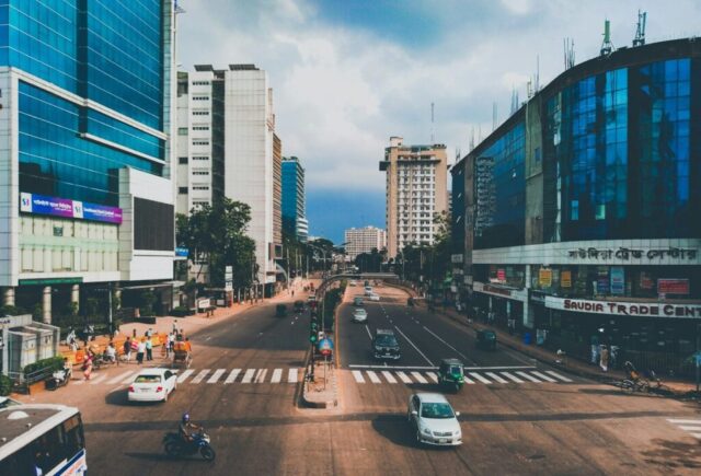 a city street filled with traffic next to tall buildings