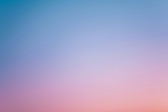 a pink and blue sky with a few clouds