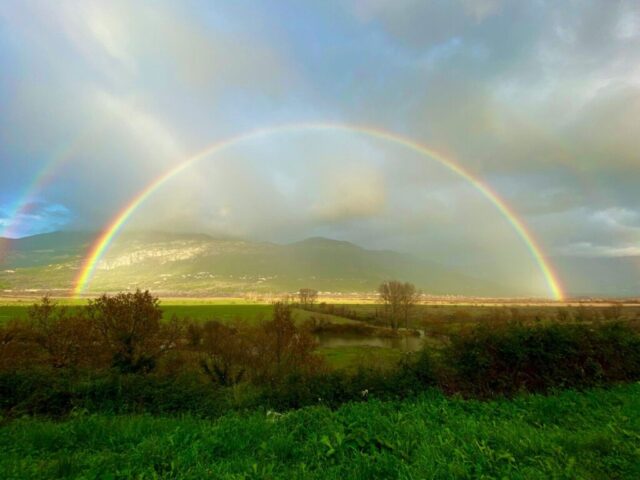 Photo by Cocodillaa.com two rainbows in the sky over a green field