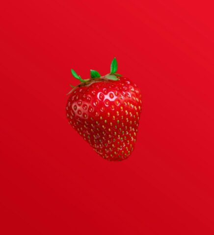A red strawberry against a red background.