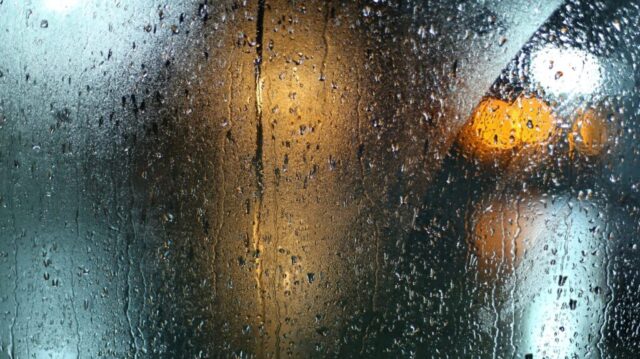 Photo by Cocodillaa.com a wet window with a traffic light on it