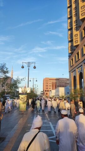 A group of men walking down a street next to tall buildings