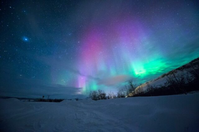 northern lights over snow-capped mountian northern lights over snow-capped mountian