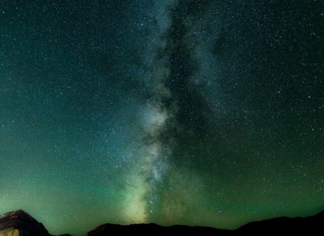 long exposure shot of stars over black mountains long exposure shot of stars over black mountains