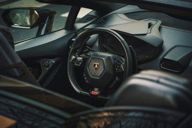 The interior of a car with a steering wheel and dashboard