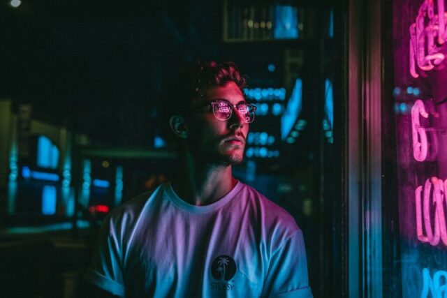 man looking at glass storefront windowpane during night