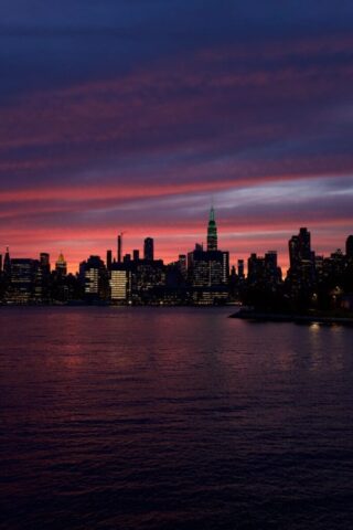 Photo by Cocodillaa.com City skyline silhouette under a vibrant, colorful sky.