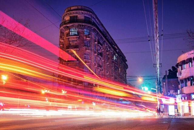 Photo by Cocodillaa.com time-lapse photography of cars passing through the road between buildings during night time