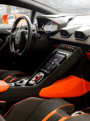 the interior of a sports car with orange trim