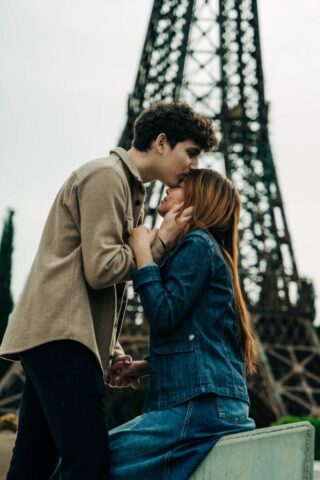 Photo by Cocodillaa.com a man and a woman kissing in front of the eiffel tower