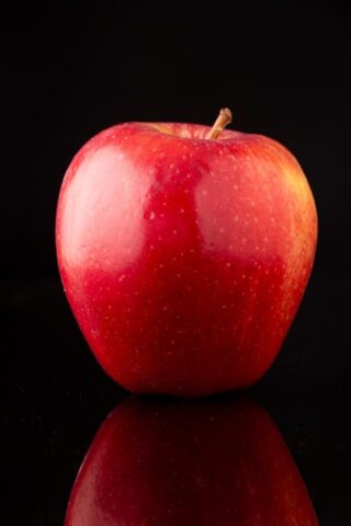 A red apple sitting on top of a table