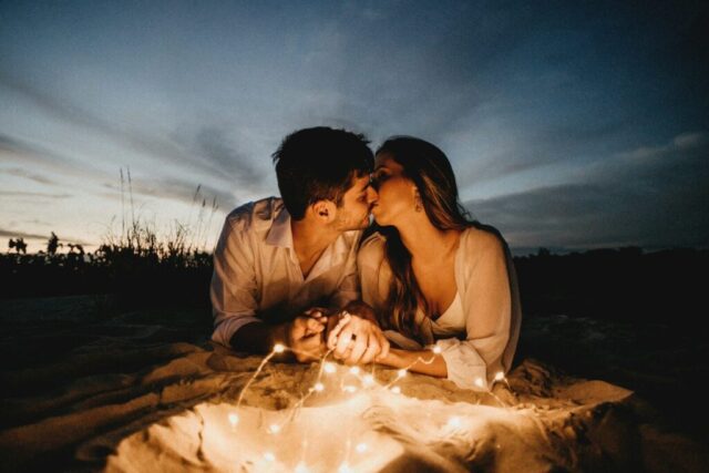Photo by Cocodillaa.com man and woman kissing on brown sand during night time