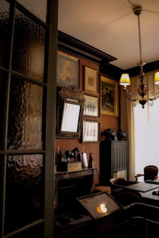 a room with a desk, chair and pictures on the wall
