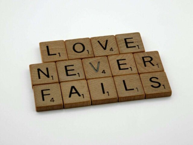 scrabble tiles spelling love never falls