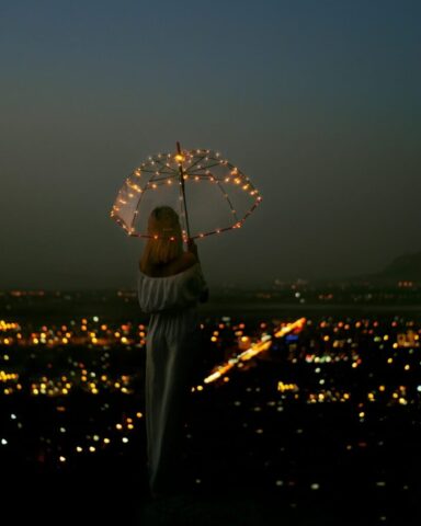 woman in white dress holding umbrella during night time