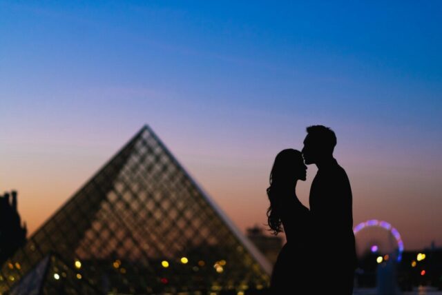 Photo by Cocodillaa.com a man and a woman standing in front of a pyramid