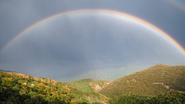 Photo by Cocodillaa.com a rainbow over a mountain
