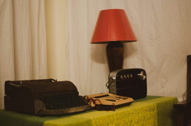 a black and red lamp on a table with a black suitcase